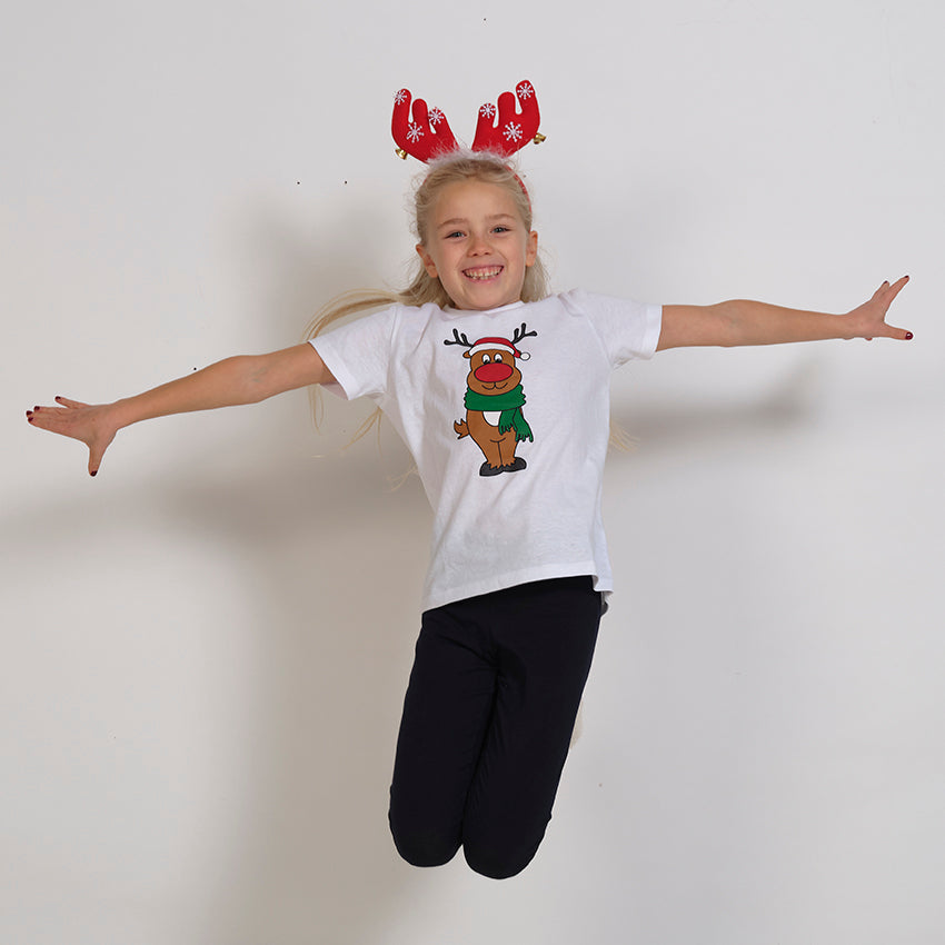 Et hoppende barn iført en hvid jule-T-shirt.